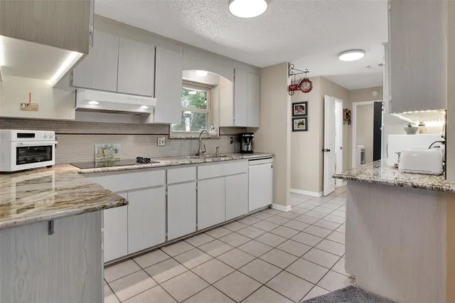 a kitchen with a sink window and cabinets