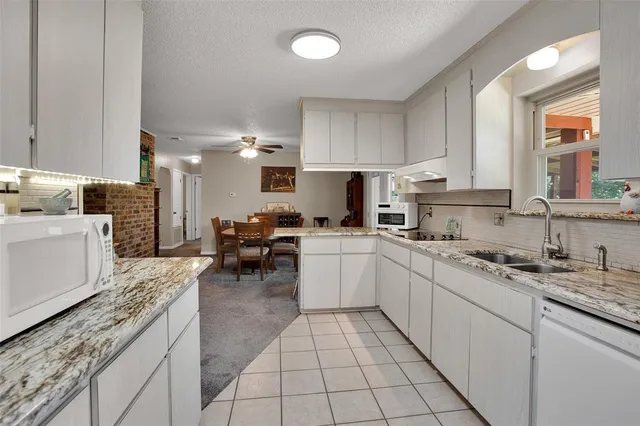 a kitchen with a sink white cabinets and counter space