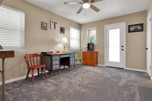 a view of a workspace with furniture and a window