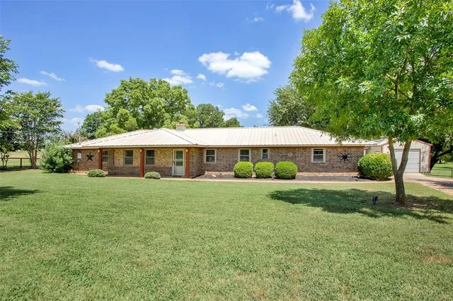 a view of a house with backyard and sitting area