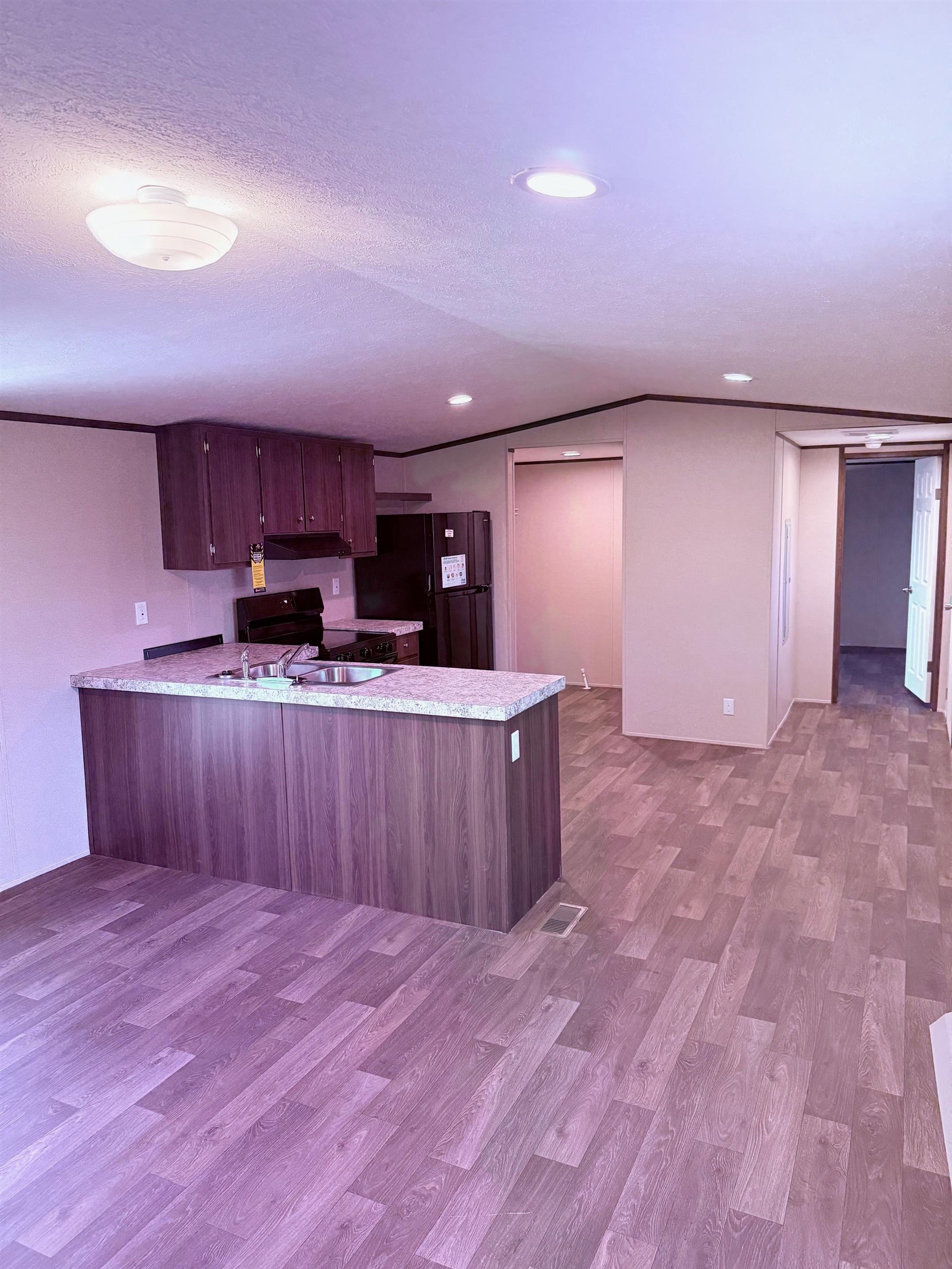 1252 Mallard Court Conway, SC 29526 - Photo 37 of 38 Kitchen with a peninsula, light countertops, light wood-style flooring, black appliances, and open floor plan