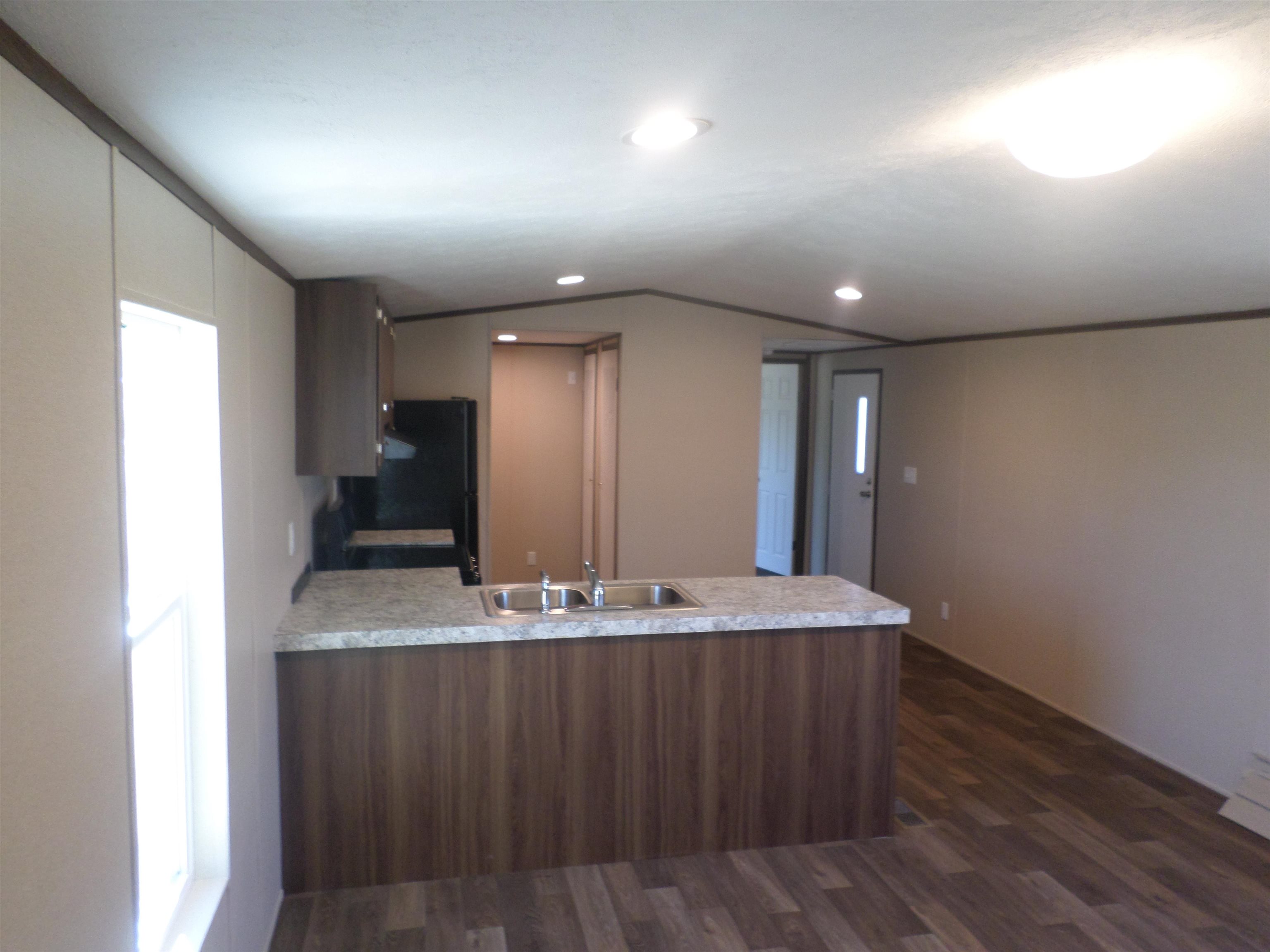 1252 Mallard Court Conway, SC 29526 - Photo 28 of 38 Kitchen featuring light countertops, a peninsula, dark wood-style flooring, freestanding refrigerator, and vaulted ceiling