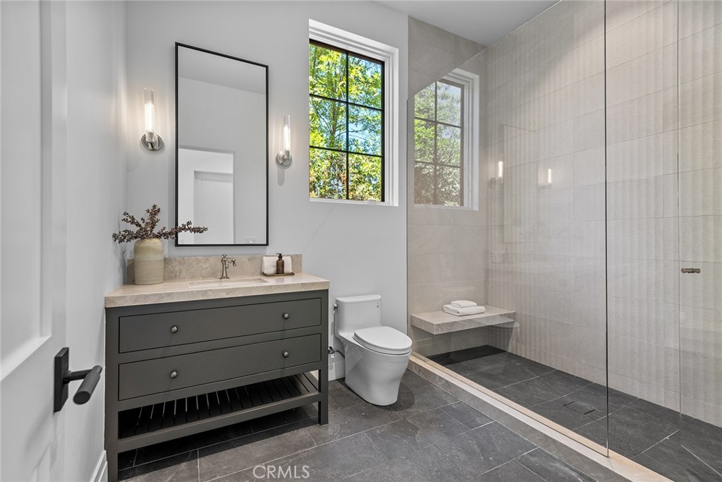 24044 Long Valley Road Hidden Hills, CA 91302 - Photo 36 of 57 a bathroom with a toilet a sink and mirror