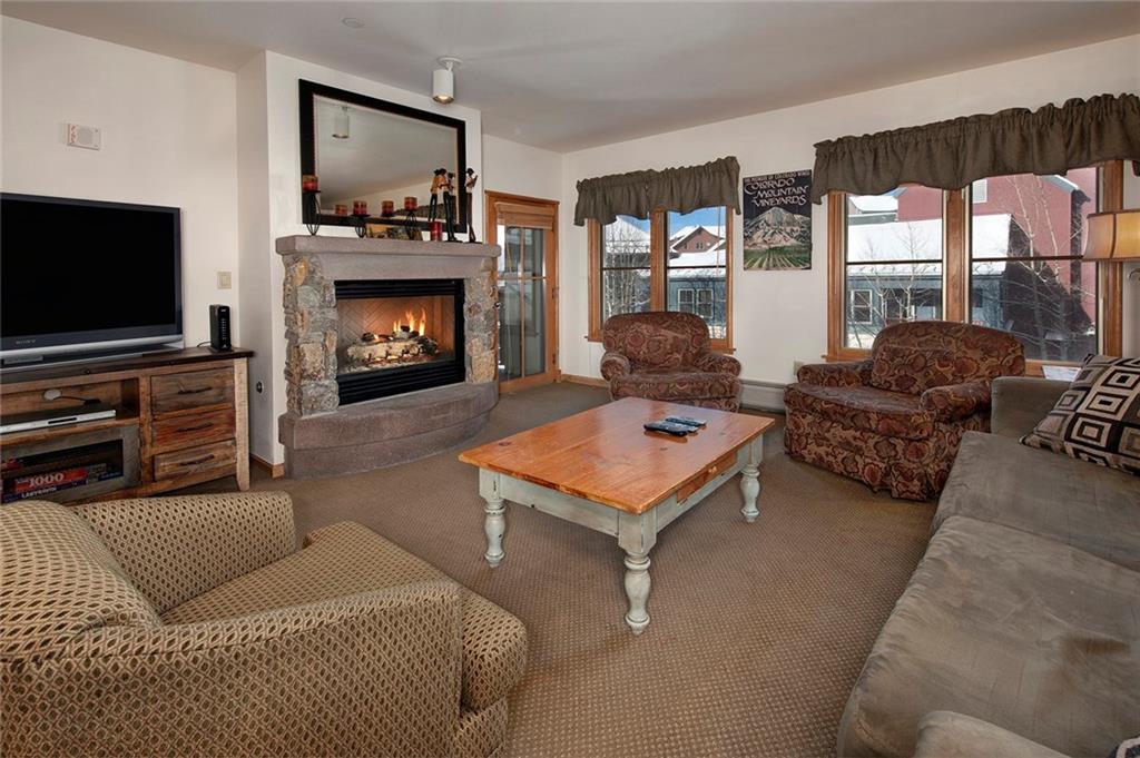 195 River Run Road, Unit 8017 Keystone, CO 80435 - Photo 2 of 32 a living room with furniture a flat screen tv and a fireplace