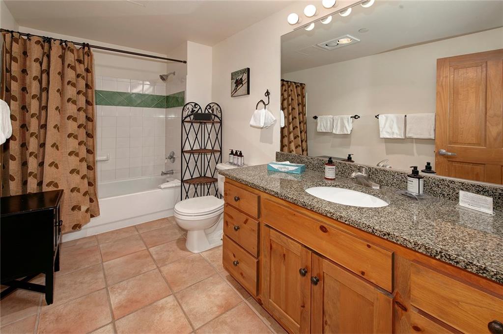 195 River Run Road, Unit 8017 Keystone, CO 80435 - Photo 21 of 32 a spacious bathroom with a granite countertop sink a toilet a mirror and shower