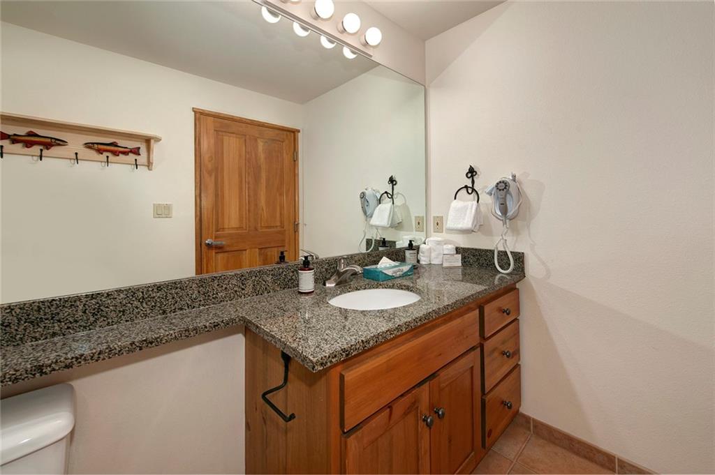 195 River Run Road, Unit 8017 Keystone, CO 80435 - Photo 22 of 32 a bathroom with a granite countertop sink and a mirror