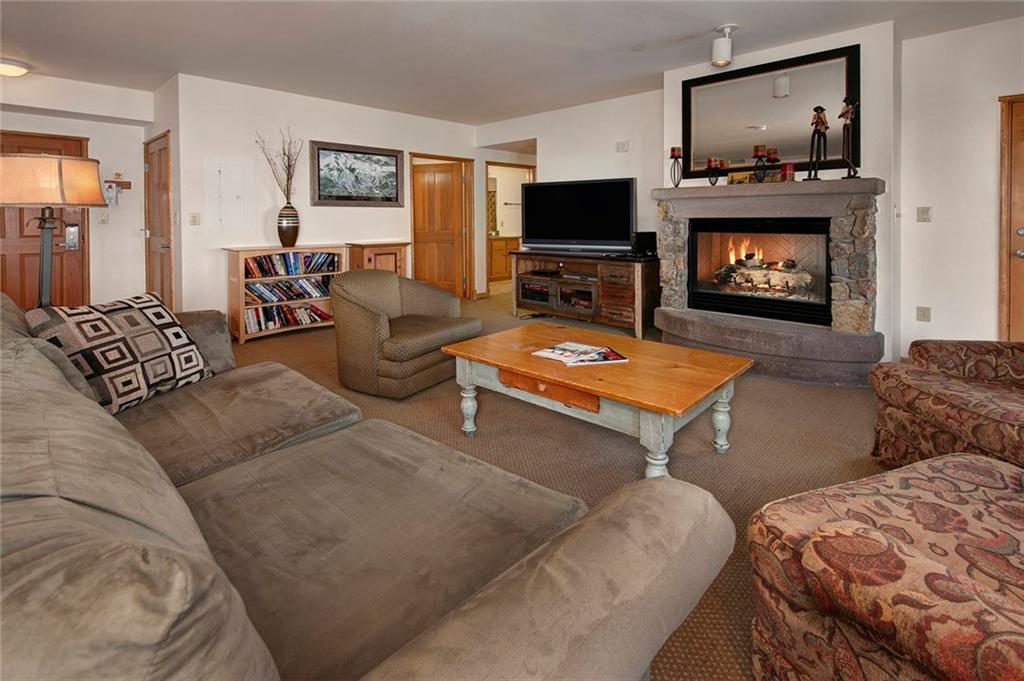 195 River Run Road, Unit 8017 Keystone, CO 80435 - Photo 4 of 32 a living room with furniture a flat screen tv and a fireplace