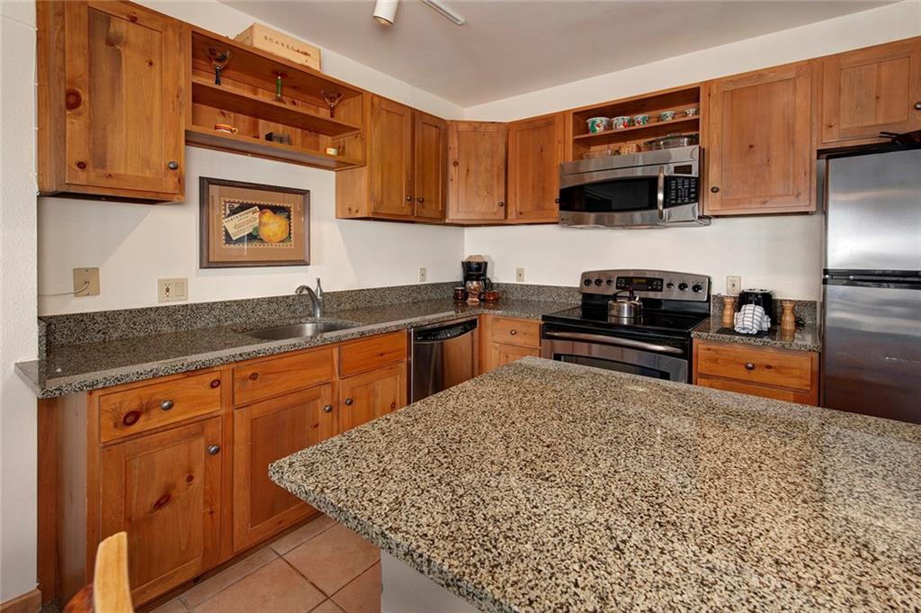 195 River Run Road, Unit 8017 Keystone, CO 80435 - Photo 9 of 32 a kitchen with stainless steel appliances granite countertop a sink stove and microwave