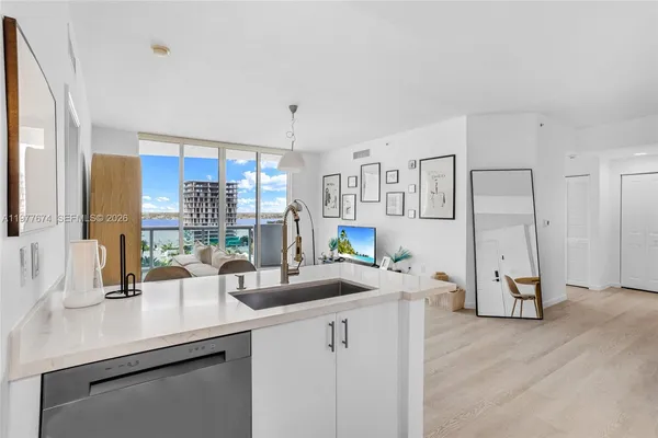 a kitchen with stainless steel appliances a sink a counter top space cabinets and wooden floor