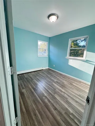 a view of a room with wooden floor and window