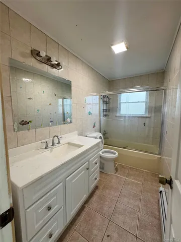 a bathroom with a granite countertop sink a toilet a mirror and shower