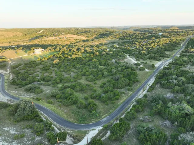 an aerial view of residential houses with outdoor space and trees