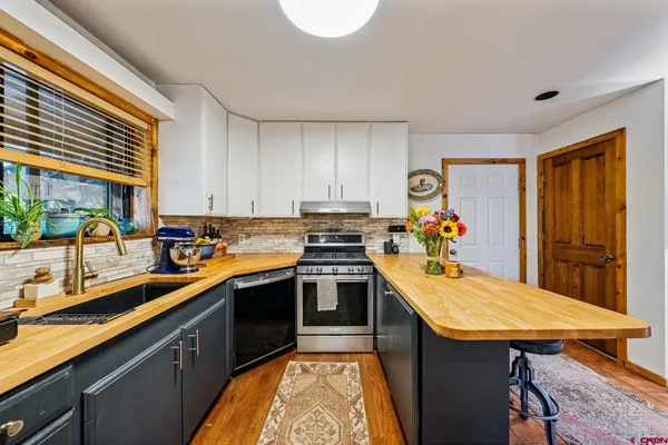 a kitchen with stainless steel appliances granite countertop a sink and cabinets