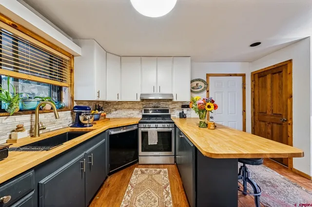 a kitchen with stainless steel appliances granite countertop a sink and cabinets
