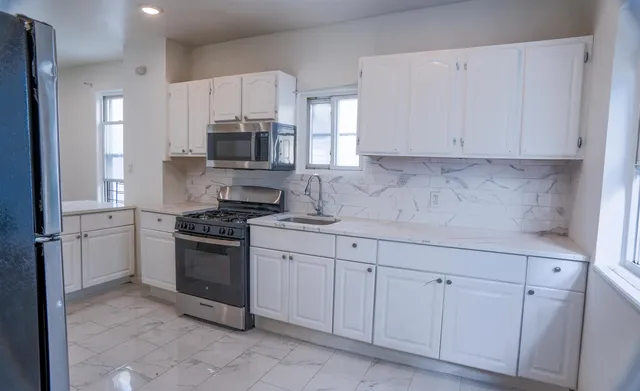 a kitchen with white cabinets stainless steel appliances and sink