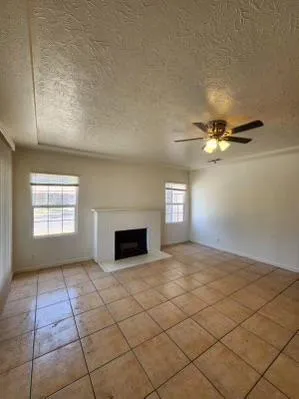 an empty room with windows and ceiling fan