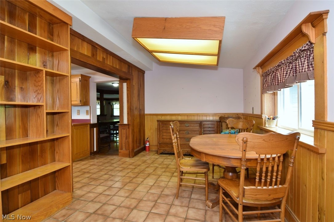 7251 Ryan Road Medina, OH 44256 - Photo 10 of 47 Room featuring extensive wood paneling, built-in shelving, and a tiled floor