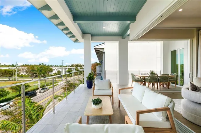 a living room with furniture a chandelier and kitchen view