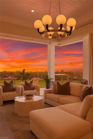 a living room with furniture a chandelier and a floor to ceiling window