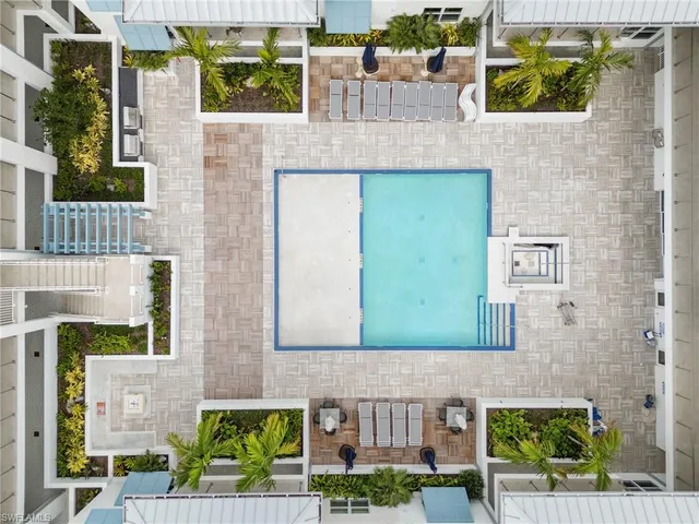 a view of a patio with dining table and chairs with plants and wooden fence