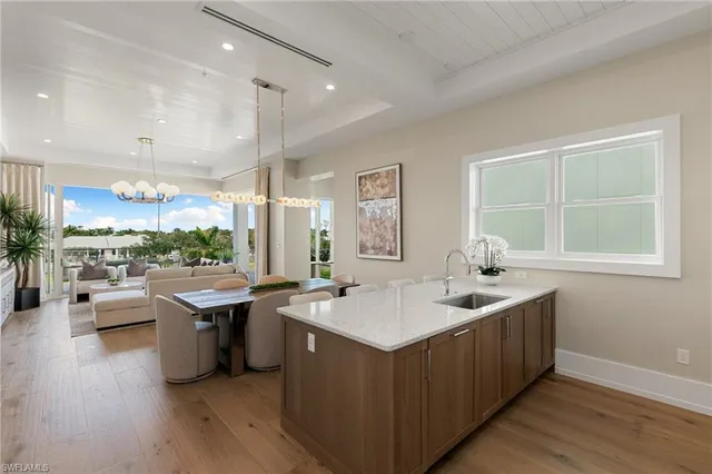 a kitchen with kitchen island granite countertop a sink cabinets and window