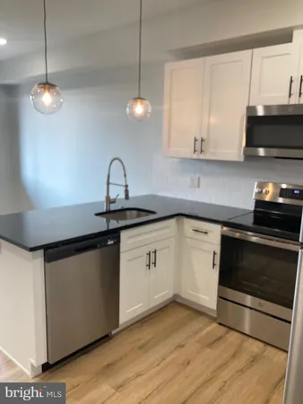 a kitchen with stainless steel appliances granite countertop a sink a stove and a microwave