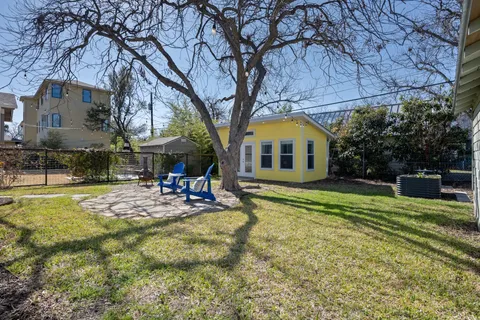 a view of a house with backyard and sitting area