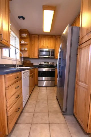 a kitchen with granite countertop a refrigerator and a stove