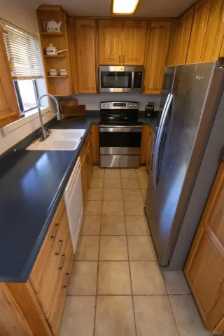 a kitchen with granite countertop a stove a sink and a microwave