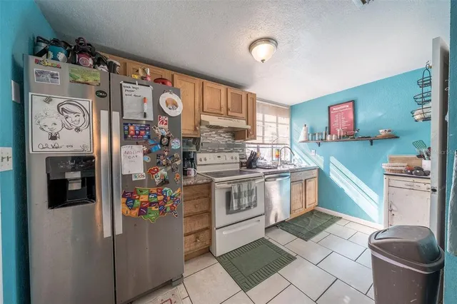 a kitchen with stainless steel appliances granite countertop a stove a refrigerator and a sink