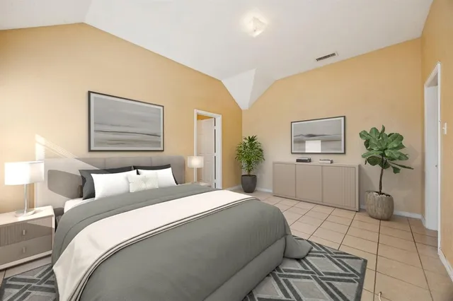 a bedroom with a large bed and a potted plant