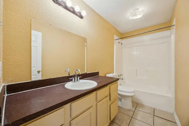 a bathroom with a granite countertop sink a toilet and a mirror