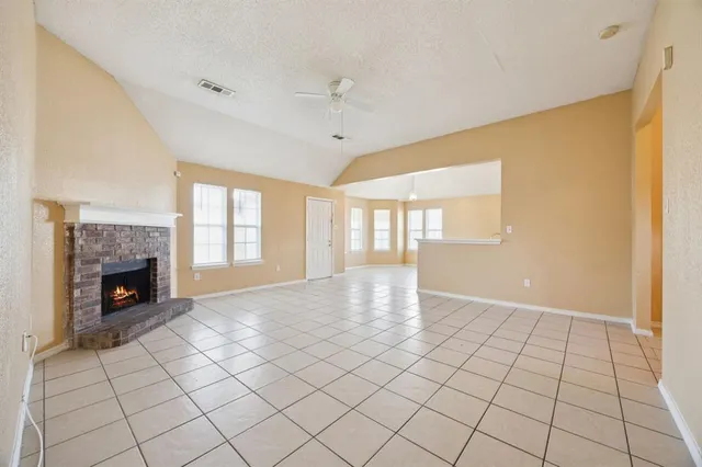 a view of an empty room with a fireplace and a window