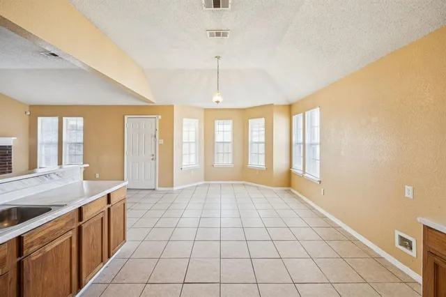 a large white kitchen with a granite countertop sink and a large window