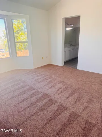 an empty room with a window and a mirror