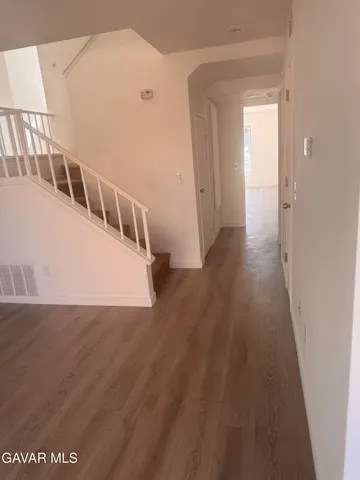 a view of a big room with wooden floor and windows