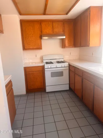 a kitchen with a stove a sink and a window
