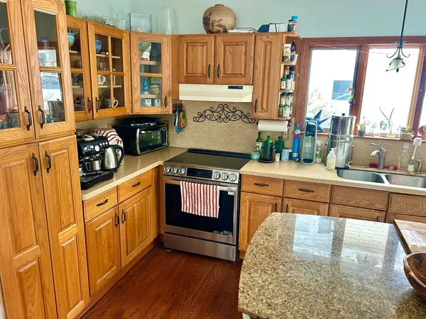 a kitchen with stainless steel appliances granite countertop a stove a sink and a refrigerator
