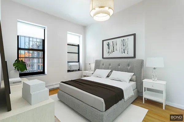 a bedroom with a bed wooden floor and window