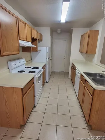 a kitchen with stainless steel appliances a sink a stove a refrigerator and cabinets