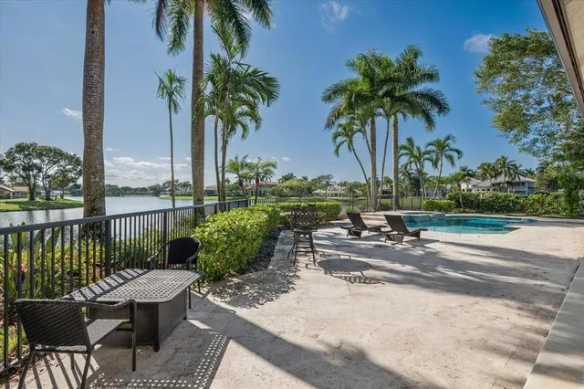 a swimming pool with outdoor seating and trees