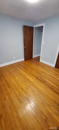 a view of an empty room with wooden floor