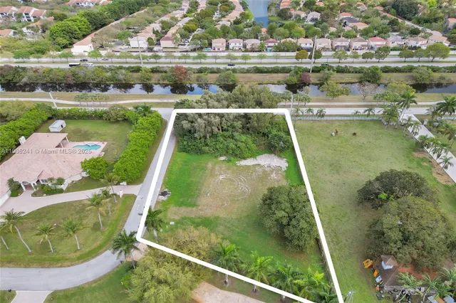 an aerial view of a residential houses with outdoor space and river