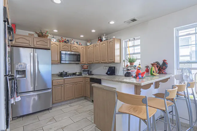 a kitchen with granite countertop a refrigerator oven a sink dishwasher and white cabinets with wooden floor