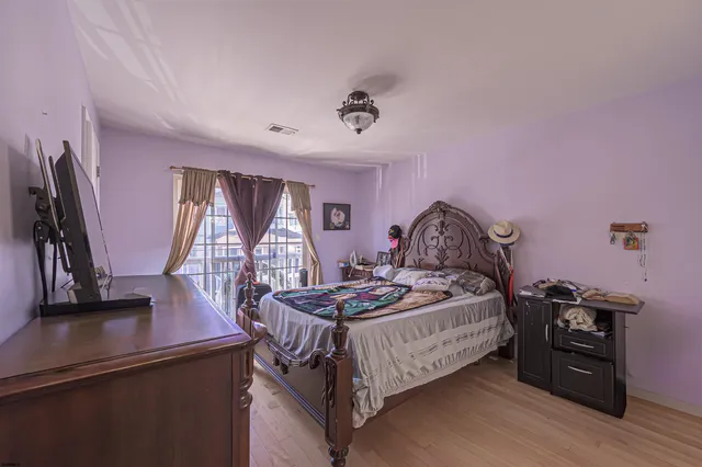 a bedroom with a bed and a flat tv screen on the dresser