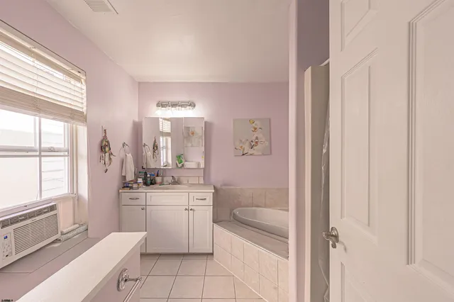 a bathroom with a sink a toilet a mirror and a tub