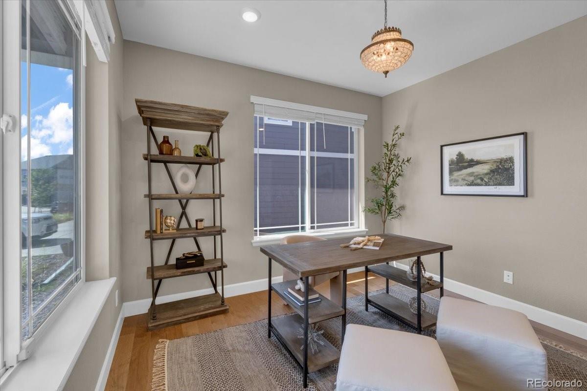 1721 Wingfeather Lane Castle Rock, CO 80108 - Photo 11 of 49 a view of a dining room with furniture wooden floor and a chandelier