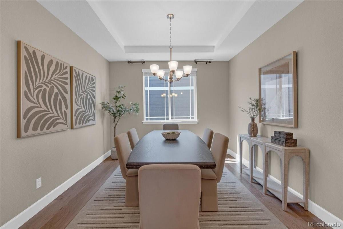1721 Wingfeather Lane Castle Rock, CO 80108 - Photo 19 of 49 a dining room with furniture a chandelier and wooden floor