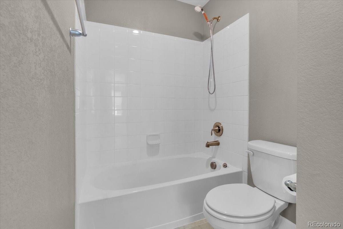 1721 Wingfeather Lane Castle Rock, CO 80108 - Photo 34 of 49 a white toilet and tub sitting next to a bathroom sink