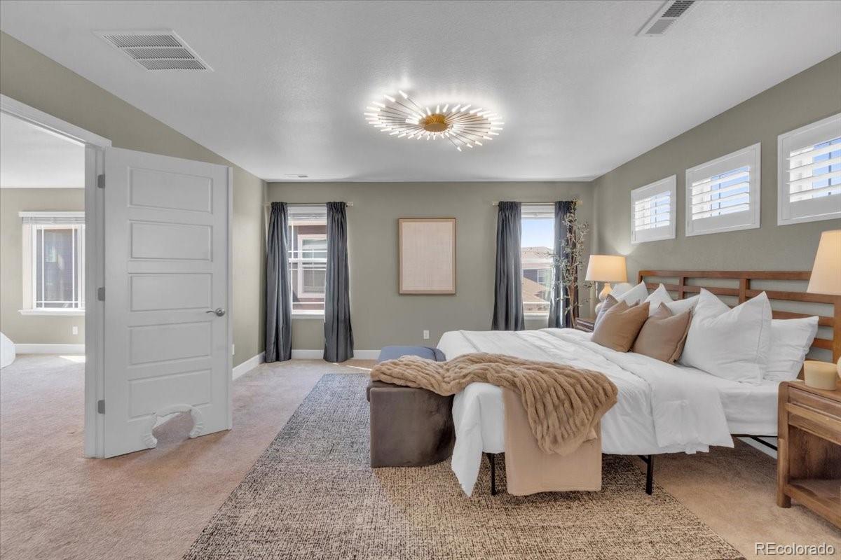 1721 Wingfeather Lane Castle Rock, CO 80108 - Photo 5 of 49 a bedroom with a bed and a chandelier